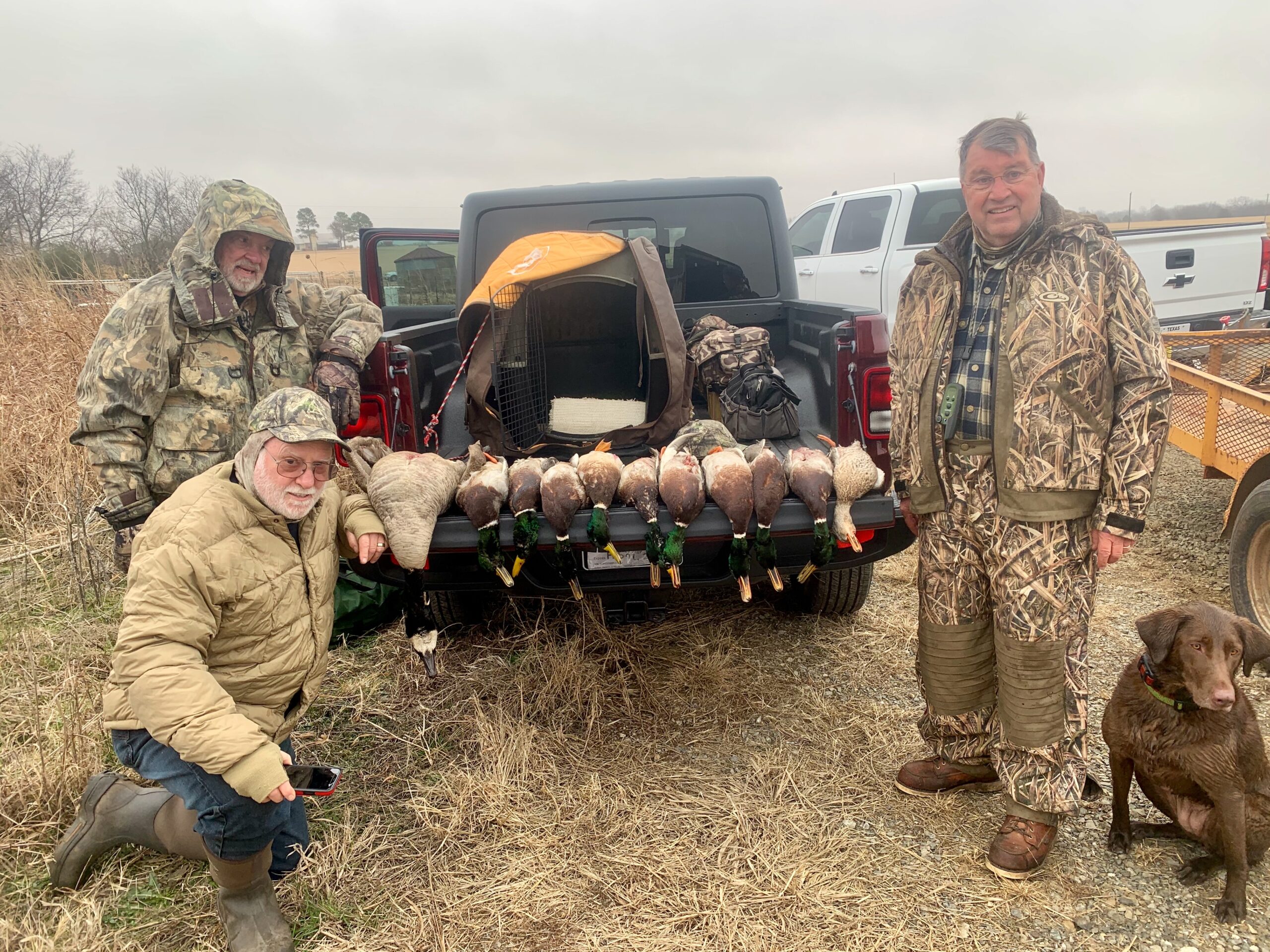 Hunters with ducks and retrieving dog